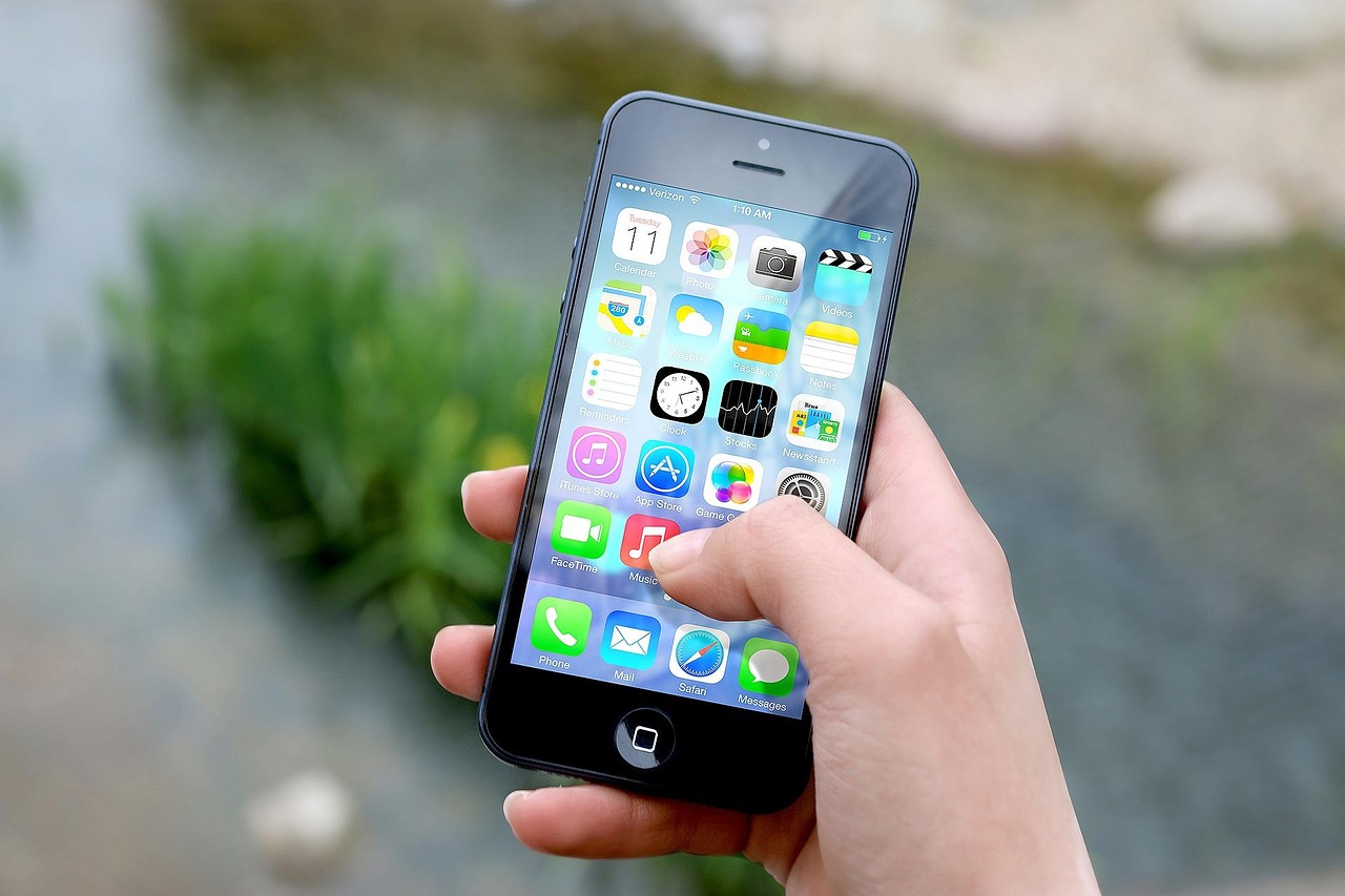 A small-business owner reviews a smartphone showing a steady stream of booked appointments after replacing an IVR phone menu.
